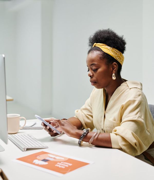 Silhouette of a person working at a computer in a modern office space.